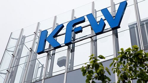kfw-beg-bundesfoerdeerung-effiziente-gebaeude Logo der KfW Bank auf einer modernen Gebäude-Fassade.